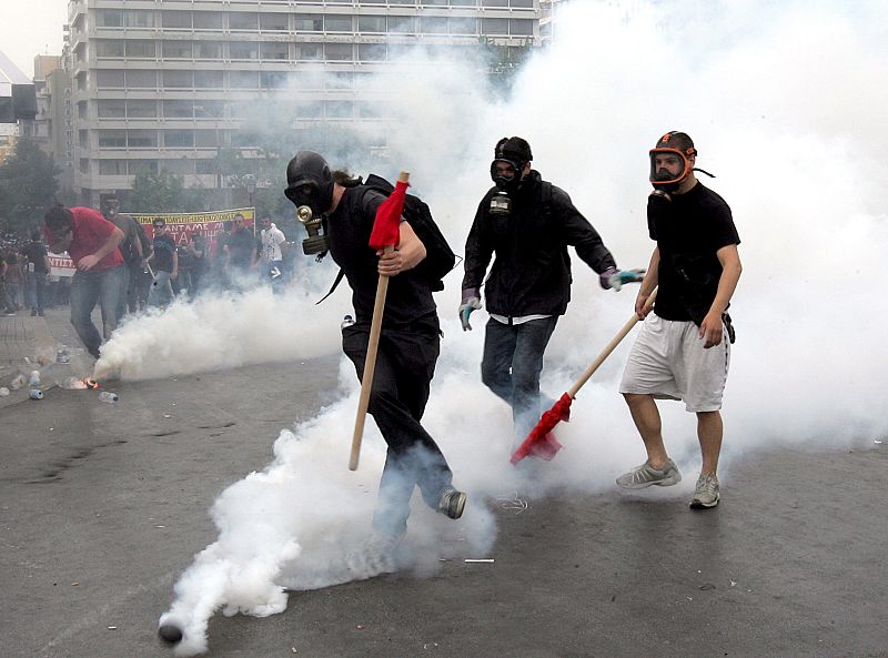 La policía antidisturbios lanza botes de humo contra los manifestantes que protestan delante del Parlamento griego en Atenas.