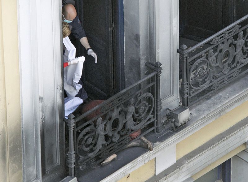 Los médicos se disponen al levantamiento del cuerpo de una mujer que ha fallecido tras el incendio de un banco durante la huelga en Grecia.