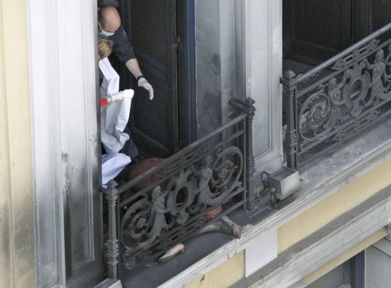 Los médicos se disponen al levantamiento del cuerpo de una mujer que ha fallecido tras el incendio de un banco durante la huelga en Grecia.