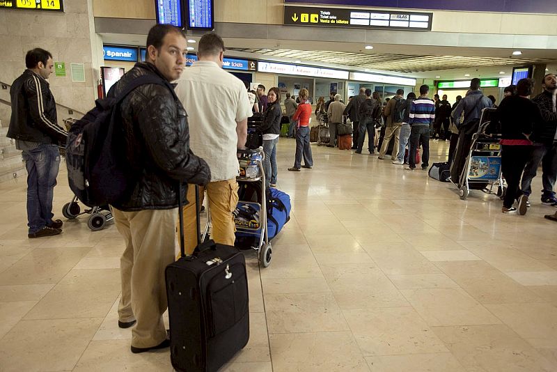 Varios pasajeros esperan en fila frente a los mostradores de facturación a que sus compañías les informen de la situación de sus vuelos en el aeropuerto de Tenerife Norte.