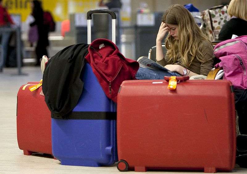 Una pasajera espera leyendo en el aeropuerto de Sevilla. La nube volcánica ha obligado a suspender alrededor de unos cuarenta vuelos en los aeropuertos de Sevilla y Jerez.