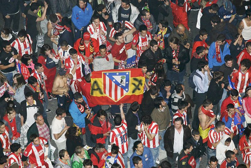 Seguidores del Atlético de Madrid se concentran en torno a la fuente.