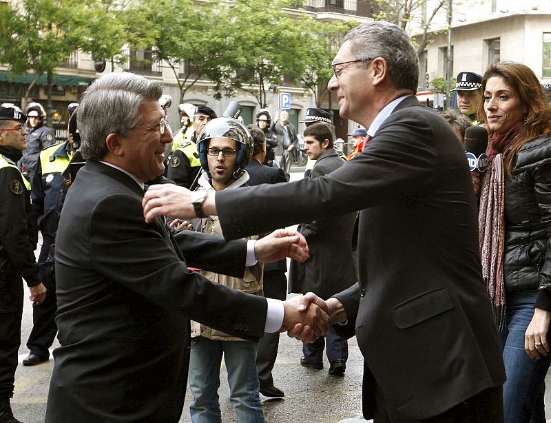 El alcalde de Madrid, Alberto Ruiz Gallardón (d) felicita al presidente del Atlético de Madrid, Enrique Cerezo (i) a su llegada a la recepción que el regidor madrileño ha ofrecido a los jugadores y directiva.