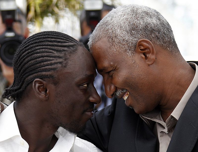 Cast members Koma and Djaoro look at each other during a photocall for the film "Un homme qui crie" at the 63rd Cannes Film Festival