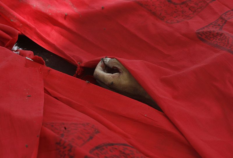 Una bandera de los "rojos" cubre uno de los muertos que se ha cobrado el asalto