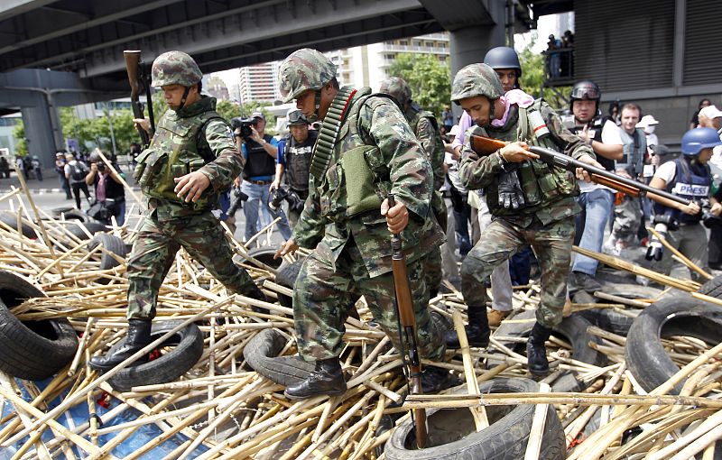 Los soldados superan las barricadas de bambú creadas por los "camisas rojas"