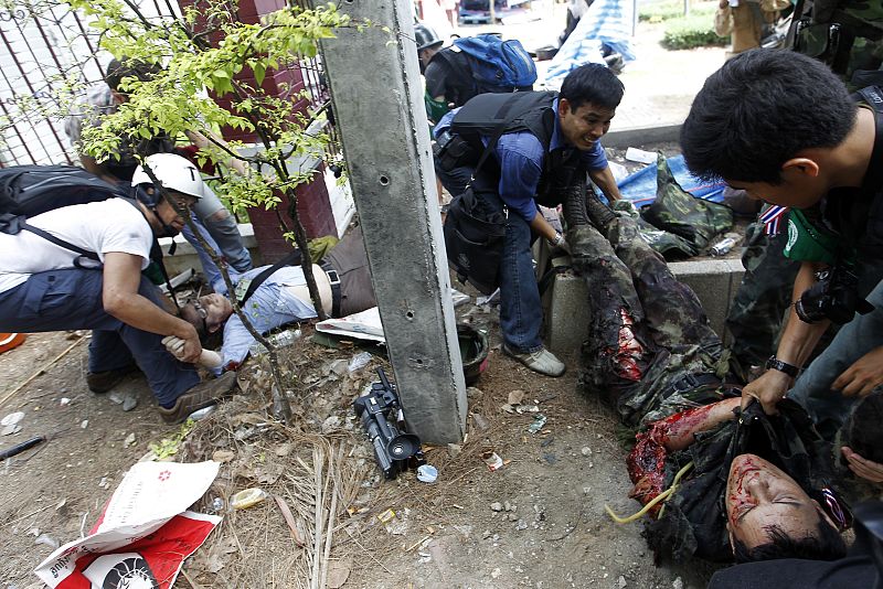 Un periodista trata de ayudar a un soldado herido durante la operación para desalojar a los "camisas rojas"