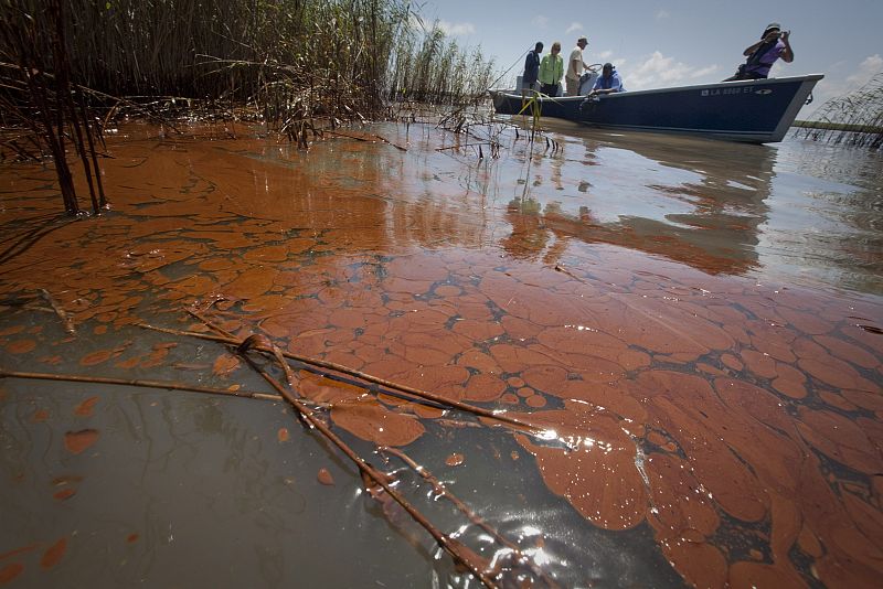 Un pequeño barco atraviesa la marea negra