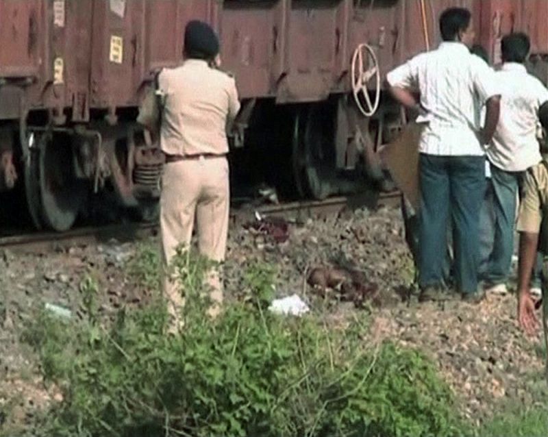 Policía y vecinos ante los trenes captados por la televisión india