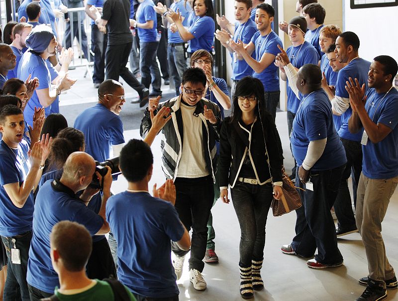 Los clientes recibidos con aplausos por los empleados en el primer día de la llegada del iPad a las tiendas londinenses. REUTERS/Luke MacGregor