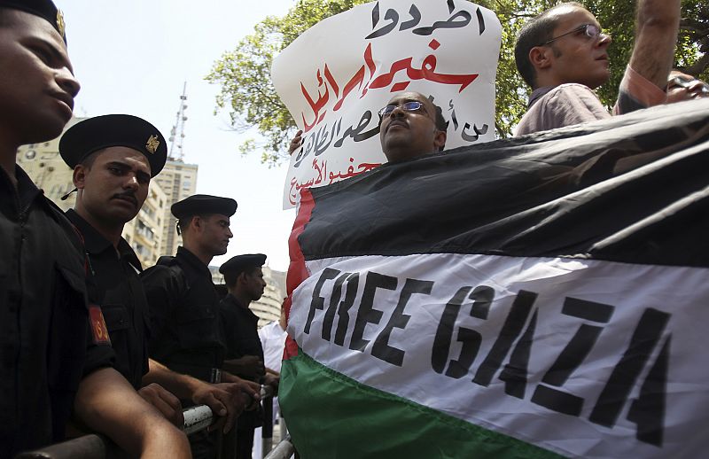 Police stand next to protesters during an anti-Israeli protest in front of the Egyptian Foreign Ministry in Cairo