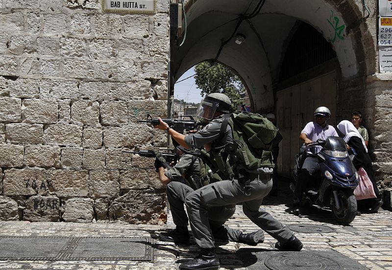 Israeli border police officers take position towards Palestinian youths throwing stones in Jerusalem