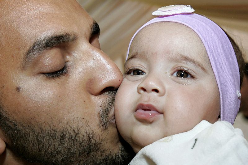 Un activista que fue detenido por Israel en la 'Flotilla de la Libertad' besa a su hija a su llegada a Jordania.