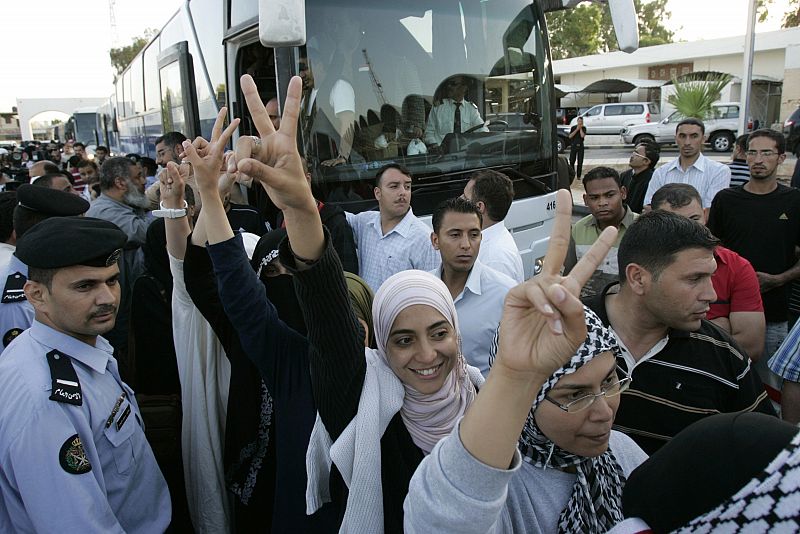 Los activistas hacen el símbolo de la victoria al cruzar la frontera entre Israel y Jordania.