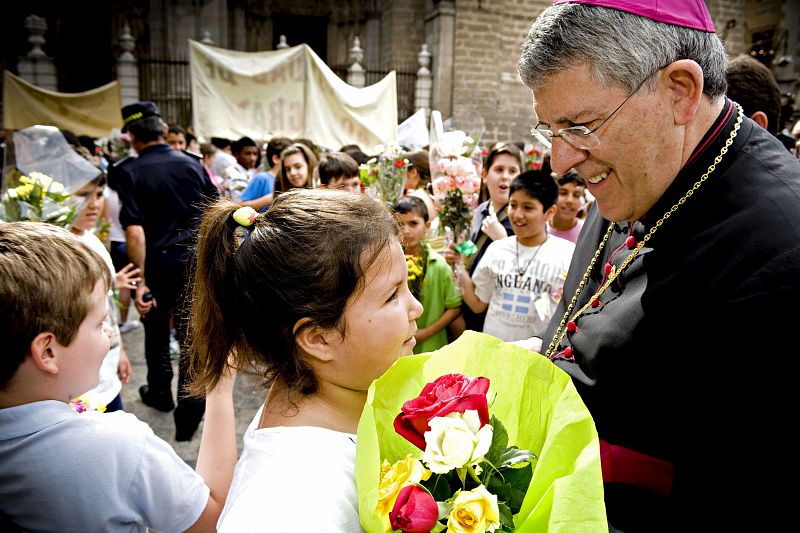 El arzobispo de Toledo, Braulio Rodriguez, saluda a unos niños durante la tradicional Ofrenda del Corpus.