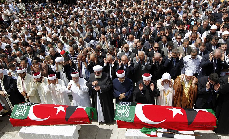 Miles de personas rezan junto a los féretros.