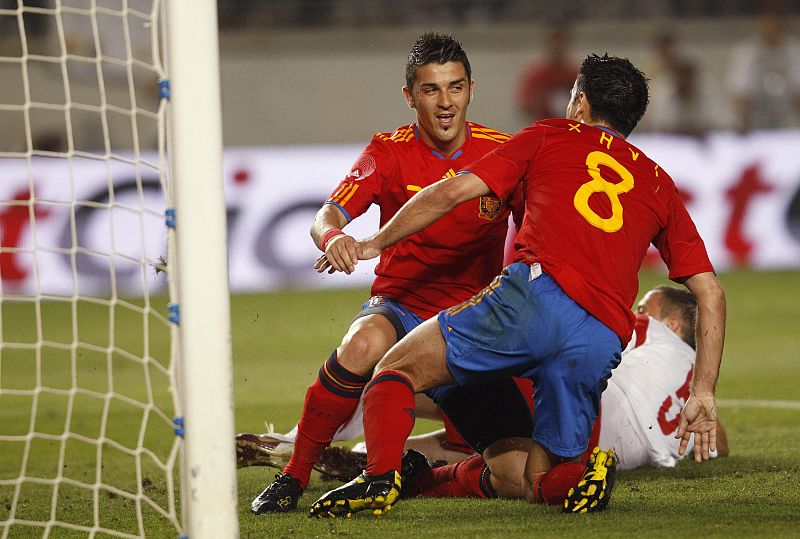 Spain's Villa celebrates with his teammate Xavi after he scored during their friendly soccer match against Poland in Murcia