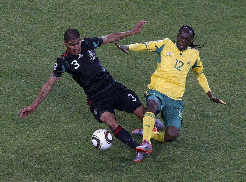 El mexicano Salcido pelea el balón con el sudafricano Letsholonyane.