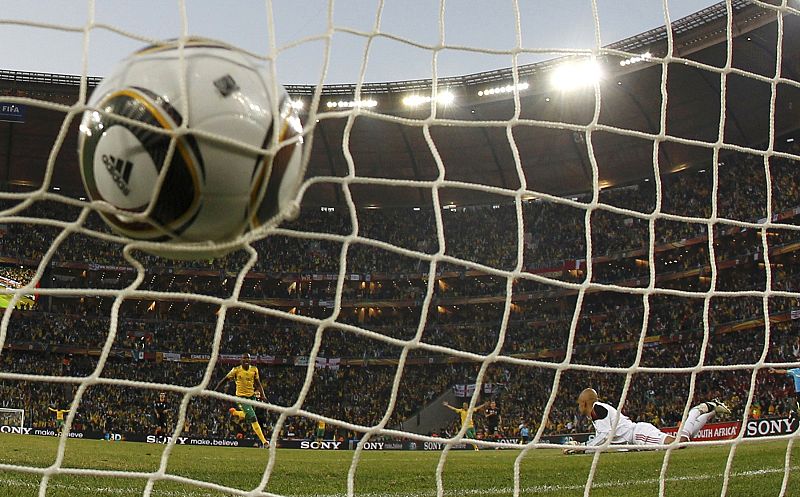 El Jabulani ha besado la red por primera vez en este Mundial de mano de su organizador. Mphela observa como se introduce el balón en la portería.