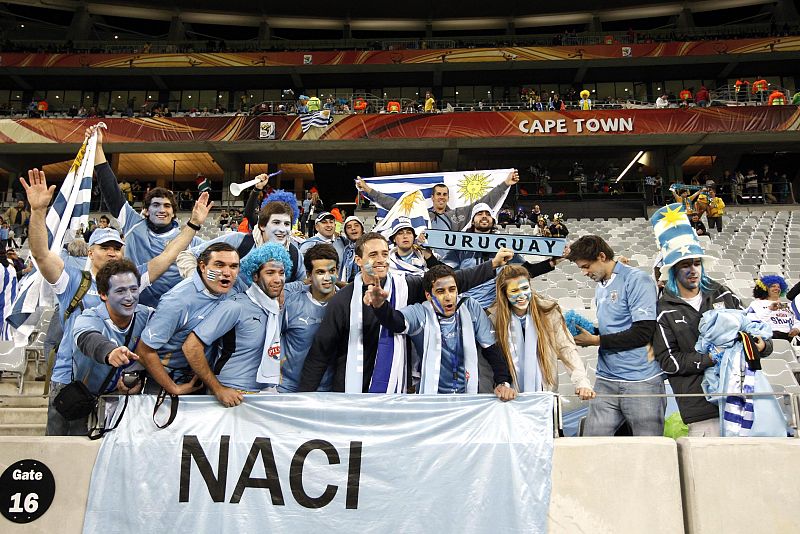 Aficionados uruguayos con los colores de su pais en las gradas del estadio Green Point