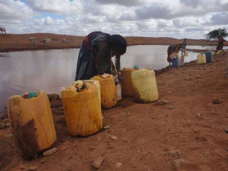 Mujeres recogiendo con bidones agua de una charca sucia, en Etiopía.
