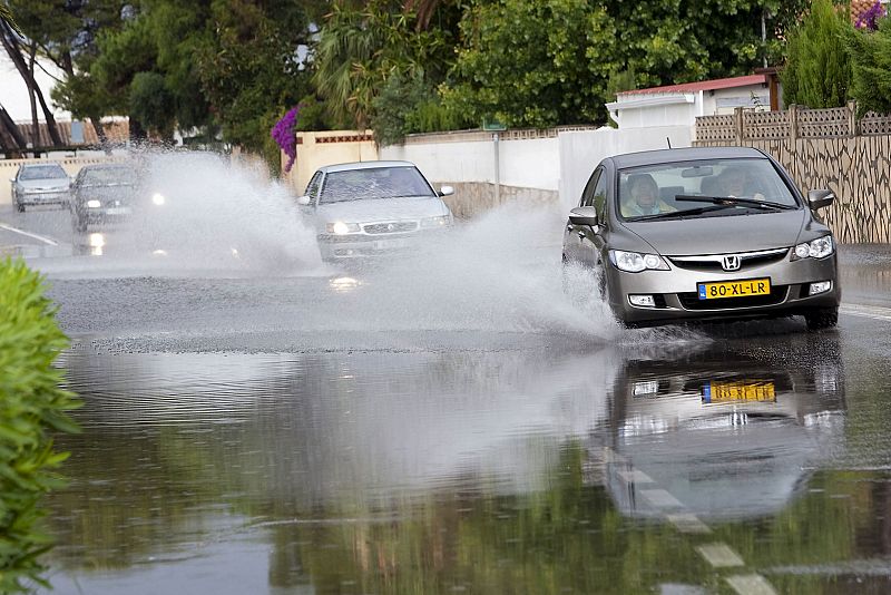 La carretera de Les Marines de Denia, parcialmente inundada a causa de las fuertes lluvias que han caído durante las últimas horas sobre el municipio, con registros de 65 litros por metro cuadrado.