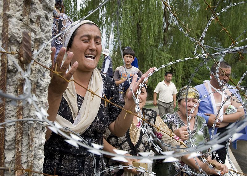 Una mujer llora en la frontera mientras espera permiso para poder desplazarse a Uzbekistan