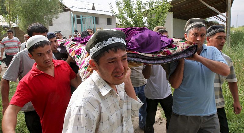 Uzbekos trasladan el cadáver de una mujer asesinada durante los violentos choques étnicos