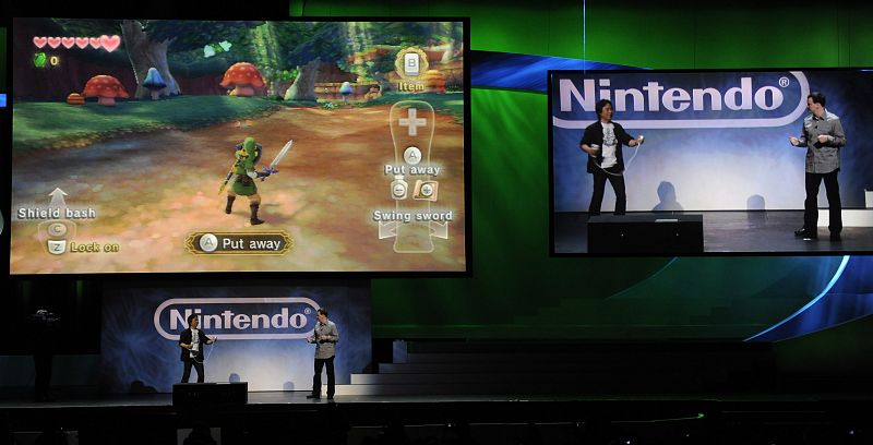 Shigaru Miyamoto (i) utiliza la nueva consola portable en 3D