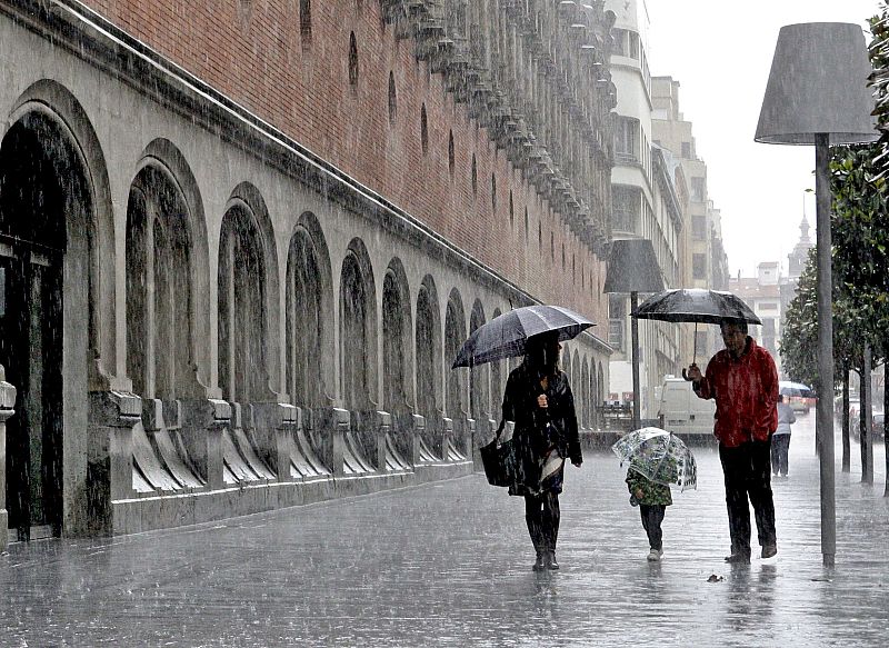 Una familia camina bajo la lluvia por una calle de Bilbao, donde las fuertes precipitaciones de las últimas horas están originando diversos problemas.