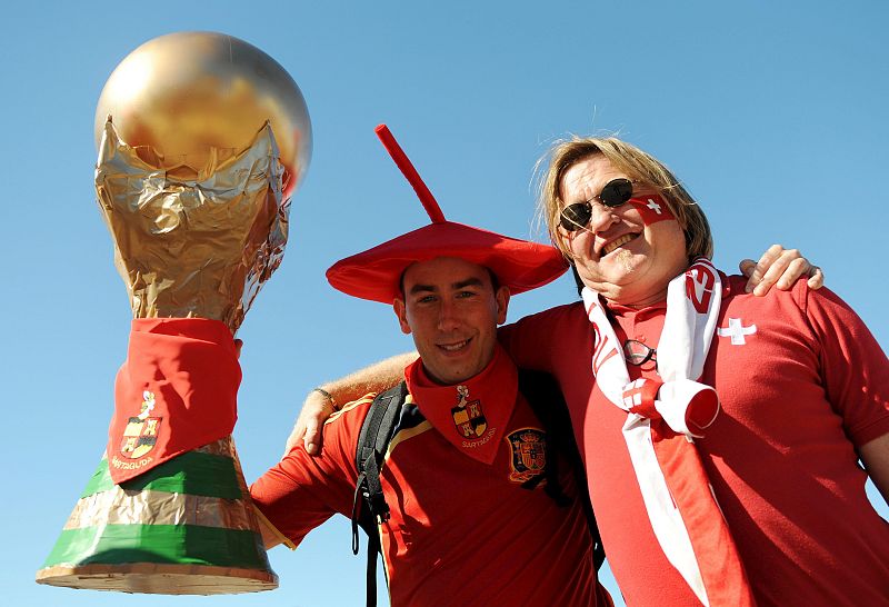 Un aficionado español y otro suizo animan a sus equipos que este miércoles disputan su el último partido de la primera ronda de la fase de grupos del Mundial de Sudáfrica.