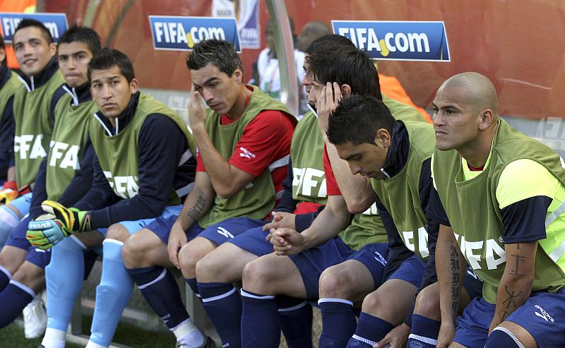 El gran ausente del choque, eldelantero chileno Humberto Suazo (d), en el banquillo antes del partido Honduras-Chile.