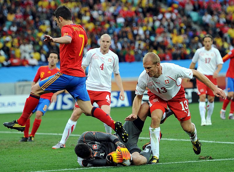 El delantero de la selección española David Villa salta por encima del portero suizo Diego Benaglio, después de que éste atrapara el Jabulani.