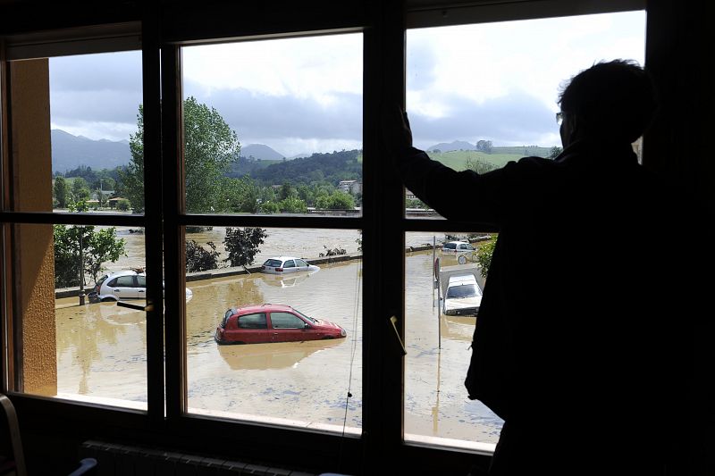 A man looks out from a town hall window in Arriondas