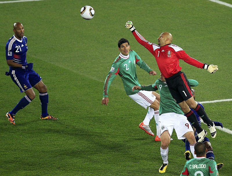 El guardameta mexicano Óscar Pérez despeja un balón ante la atenta mirada del francés Anelka.