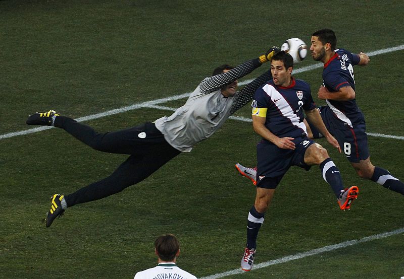 Slovenia's goalkeeper Samir Handanovic punches the ball away from Carlos Bocanegra and Clint Dempsey (R) of the U.S. during their 2010 World Cup Group C soccer match at Ellis Park stadium in Johannesburg