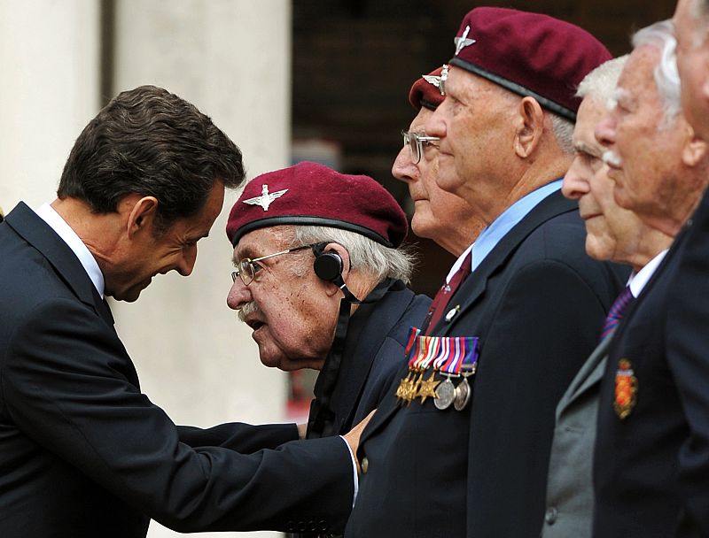 Nicolás Sarkozy dialoga con uno de los veteranos de la Segunda Guerra Mundial presentes en el acto.