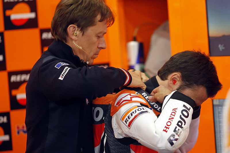 Mike Leitner, jefe de mecánicos de Dani Pedrosa, le ayuda dentro de su 'box'.