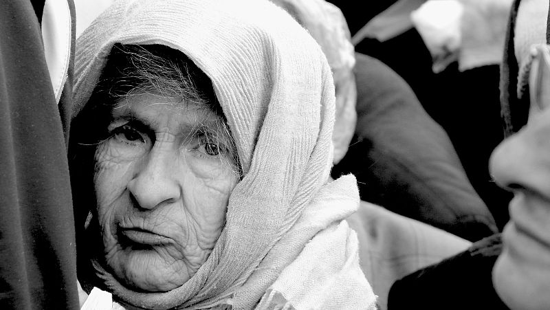 Bosnia 2010. Anciana en cola de indigentes para recoger leche y pan