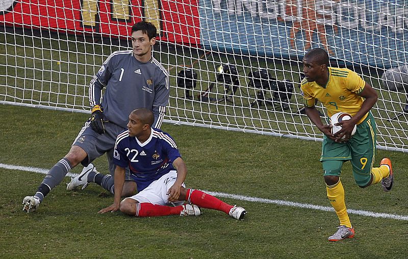 El jugador sufafricano Mphela tras marcar el segundo gol para Sudáfrica, recoge el balón ante la mirada Clichy y Lloris.