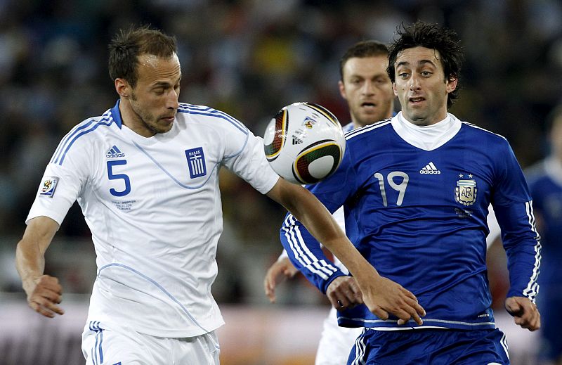 El delantero argentino Diego Milito lucha por el balón con el griego Vangelis Moras.