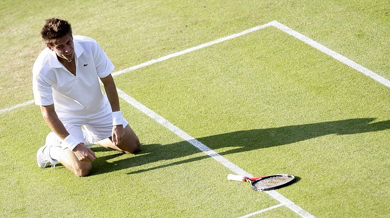 El tenista francés Nicolas Mahut se arrodilla en el césped por el cansancio sufrido durante el partido.