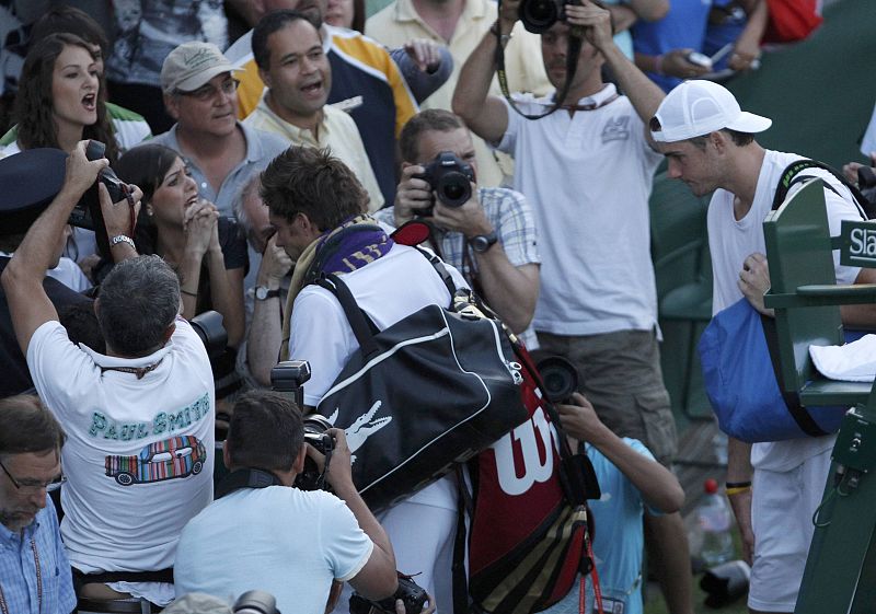 John Isner y Nicolas Mahut abandonan la pista de tenis después de que fuera suspendido el partido en la primera ronda del torneo de Wimbledon 2010.