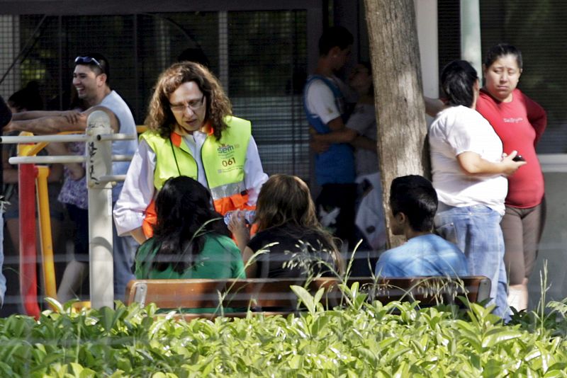 Una trabajadora de Protección Civil asiste a algunos familiares.