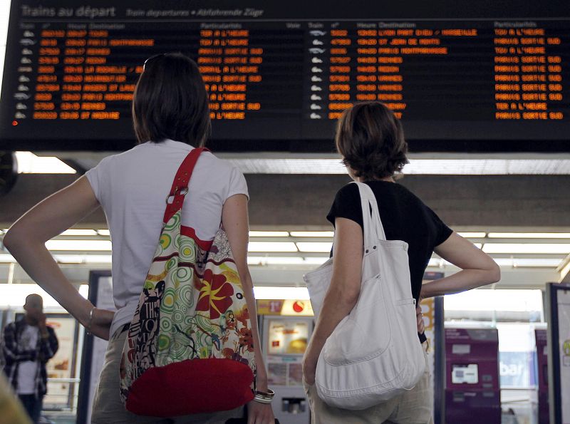 Dos chicas miran los paneles de información de los trenes en la estación de Nantes (Francia)