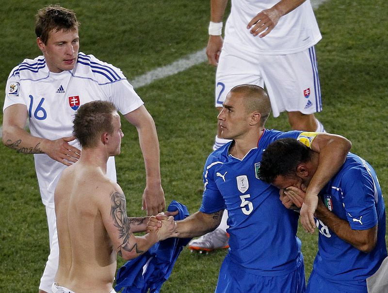 'Il Capitano' Fabio Cannavaro consuela a su paisano napolitano Quagliarella instantes después del término del partido.