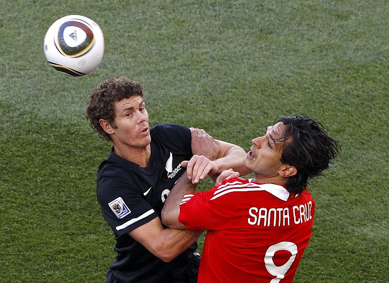 El neocelandésTony Lochhead y Roque Santa Cruz pelean la posesión del balón en el partido que se ha disputado en el estadio Peter Mokaba.