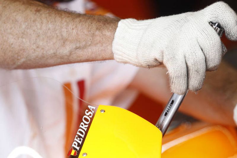 Uno de los mecánicos de Pedrosa trabaja con guantes 'especiales'.