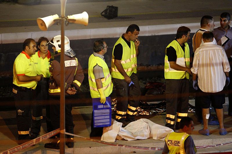 Judicial police make arrangements to collect the bodies of victims at the Castelldefels Beach station near Barcelona