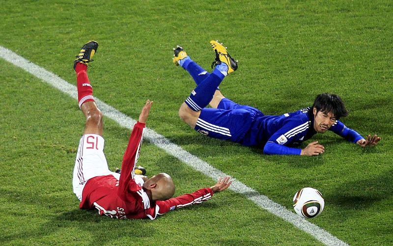 Denmark's Poulsen and Japan's Abe fall during a 2010 World Cup Group E soccer match at Royal Bafokeng stadium in Rustenburg